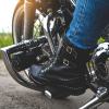 Black leather boots of a motorcyclist, on the bike's pegs