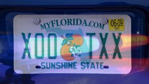 A Florida license plate with an overlaying semi-transparent image of police lights on over it