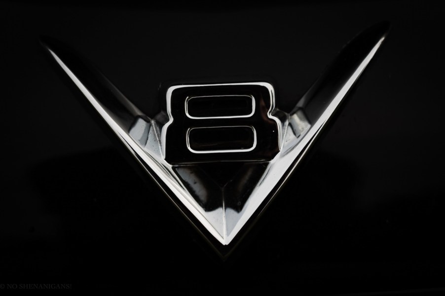 The chrome "V8" hood ornament from a car.