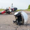 A helmet and motorcycle lying in the road