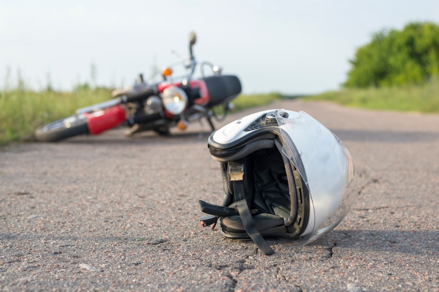 A helmet and motorcycle lying in the road