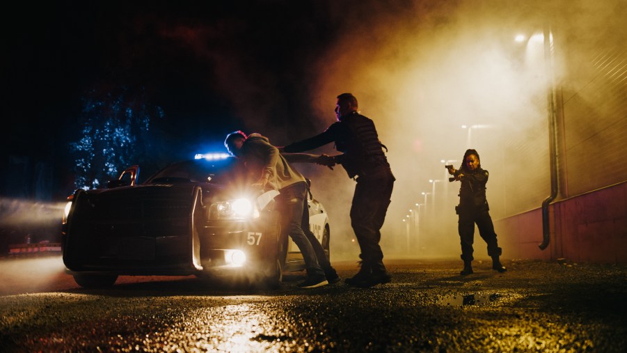 A police officer arresting a man at night