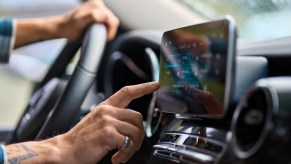 A man using a touchscreen is a car