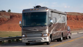 An RV on the road towing an SUV