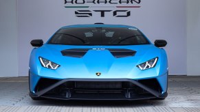 A blue Lamborghini Huracan sits in front of sign that reads, "Huracan STO"