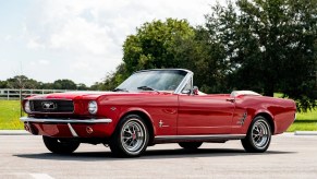 A red 1966 Ford Mustang convertible parked in left side angle view