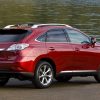 A red 2010 Lexus RX 350 SUV parked in front of water in right ear angle view