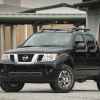 A black 2014 Nissan Frontier truck parked in left front angle view