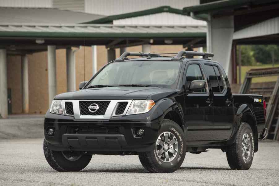 A black 2014 Nissan Frontier truck parked in left front angle view