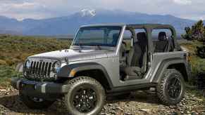 Silver 2015 Jeep Wrangler parked near mountains in left front angle view