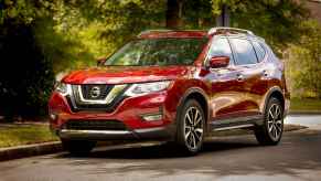 A red 2019 Nissan Rogue parked on a shaded street