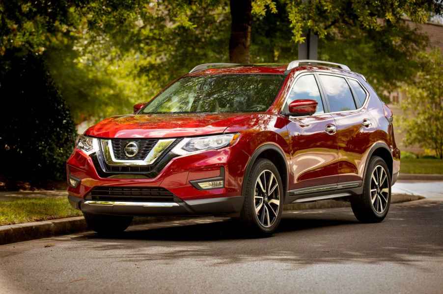 A red 2019 Nissan Rogue parked on a shaded street