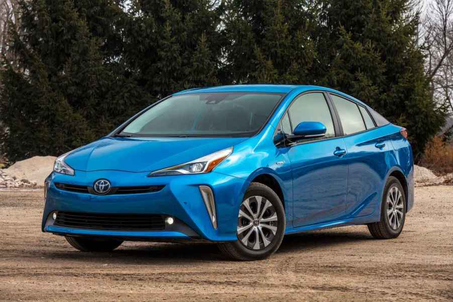 A blue 2019 Toyota Prius parked outside in left front angle view