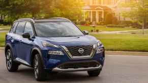 A blue 2021 Nissan Rogue parked on a residential street in right front angle view