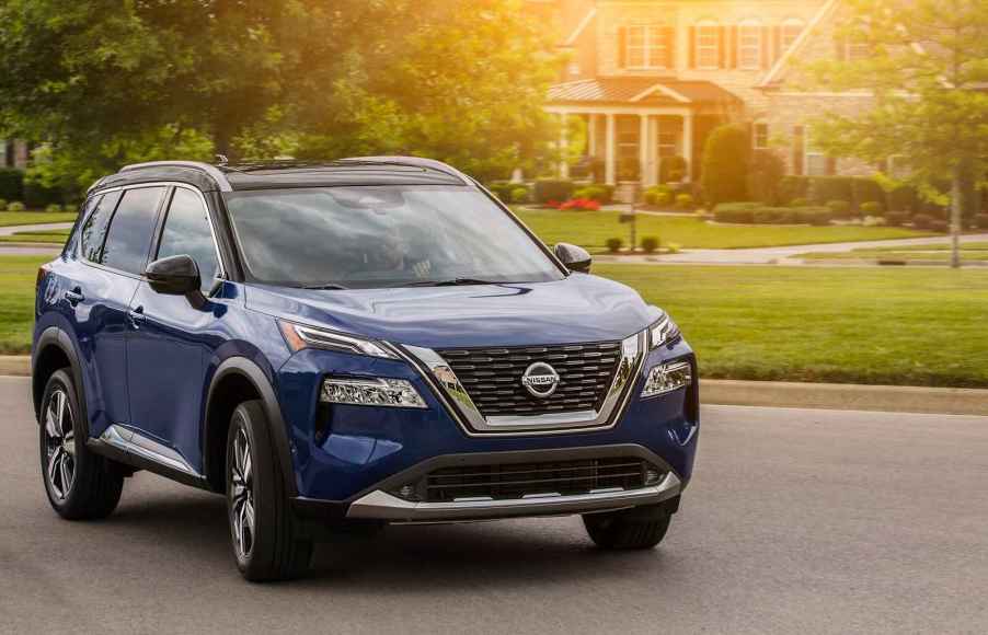 A blue 2021 Nissan Rogue parked on a residential street in right front angle view