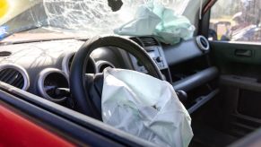 The interior of a crashed car with airbag deployed.