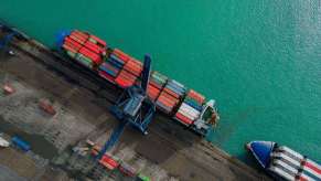 A cargo ship near another vessel at a large maritime port.