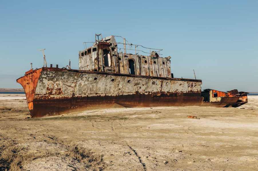 Scrapped ship, dismantled on a beach, the sea in the background.