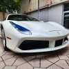 Whiter Ferrari spider car at a dealership