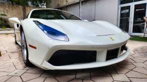 Whiter Ferrari spider car at a dealership