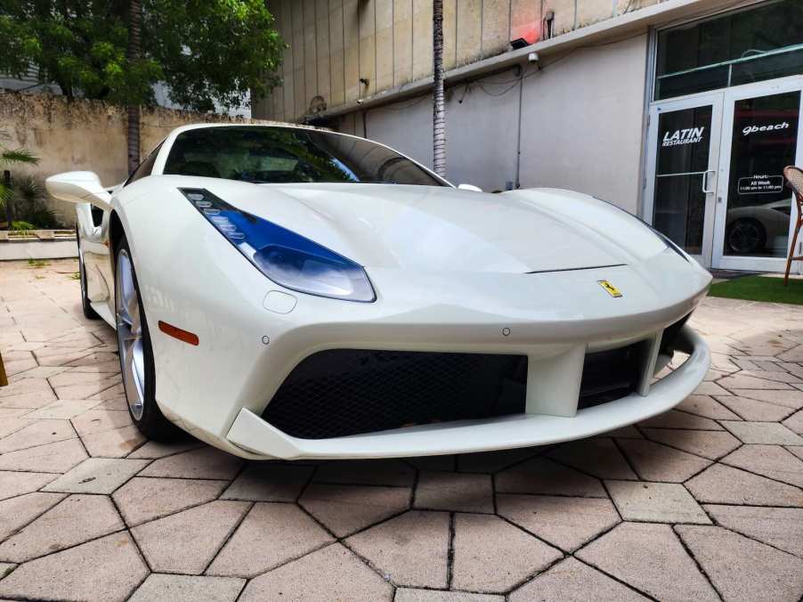 Whiter Ferrari spider car at a dealership