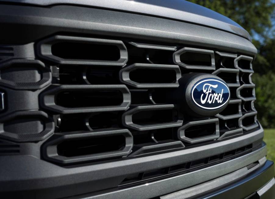 A Ford F-150 grille with a badge on it