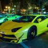 Lamborghini supercars parked at a luxury car show in Qatar, the city visible in the background.