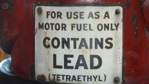 White "contains lead" label on a red gas canister.