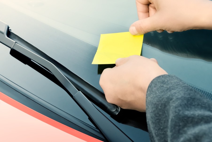 Driver leaving a note on a car after a hit-and-run accident