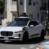 A Waymo self-driving car at an emergency scene with firefighters.