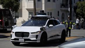 A Waymo self-driving car at an emergency scene with firefighters.