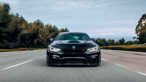 A black BMW driving in direct front view