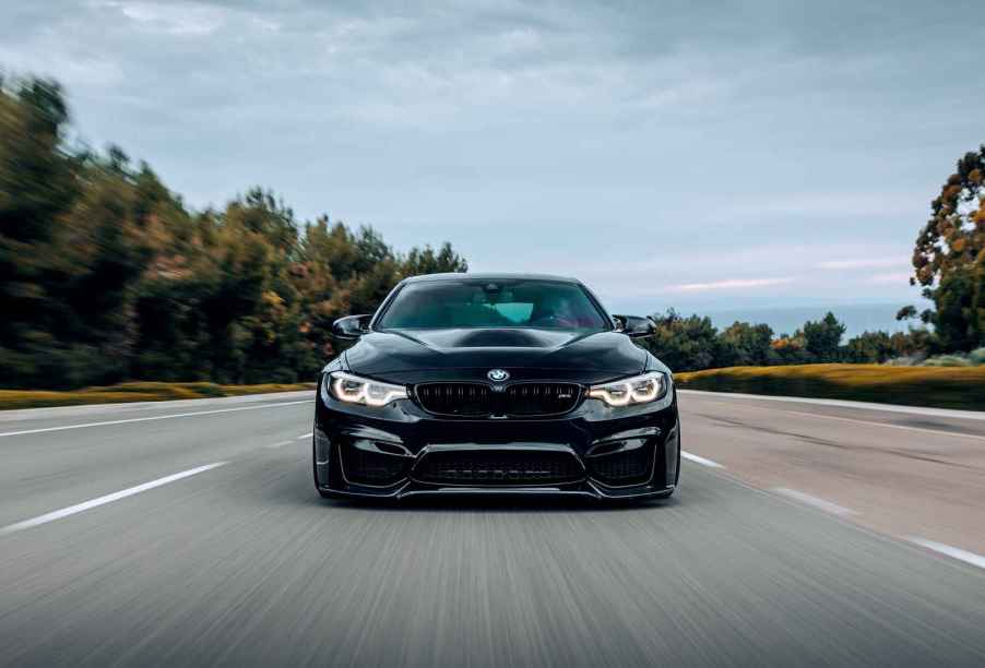 A black BMW driving in direct front view