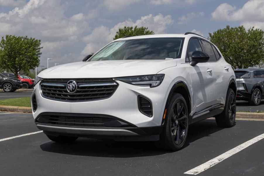 A white Buick Envision SUV sitting in a parking lot in close lower left front corner view