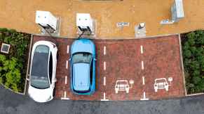 Electric vehicles charging at a charging station, with two EVs parked and charging while two spots remain empty