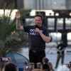 Elon Musk speaking to a crowd in front of a SpaceX craft wearing an "Occupy Mars" t-shirt