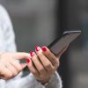 A woman reading a text message on her smartphone