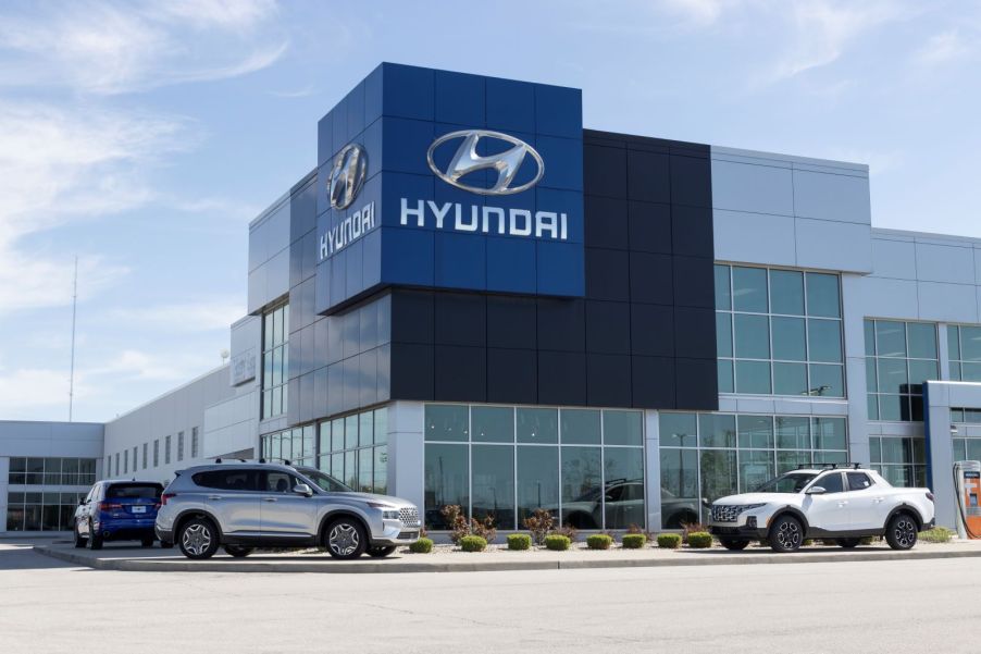 The exterior of a Hyundai dealership, with three cars sitting outside of the building