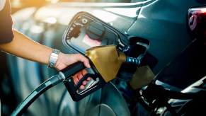 A person filling their SUV with gas