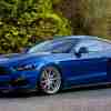 A blue 2017 Ford Mustang GT posed for pictures in an empty parking lot