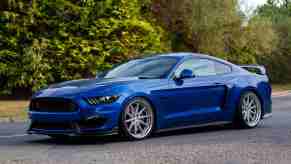 A blue 2017 Ford Mustang GT posed for pictures in an empty parking lot