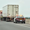 A police car behind a semi-truck