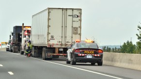 A police car behind a semi-truck