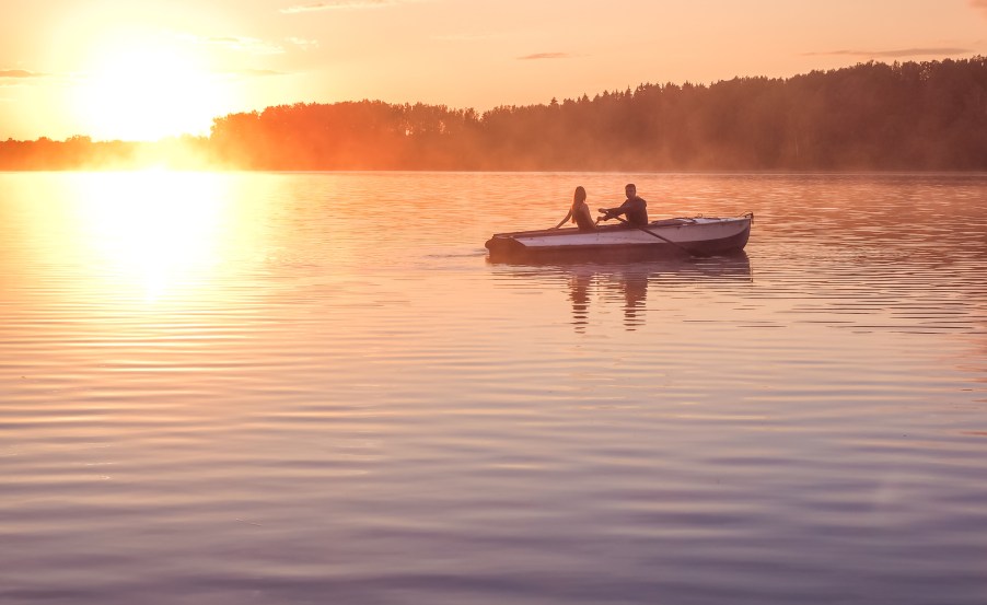 A couple in a rowboat at dusk