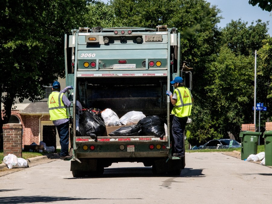 Two man and a garbage truck collecting trash