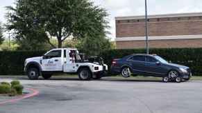 A Mercedes being towed away by a tow truck