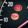 An oil can and exclamation point on car dashboard indicate low oil life