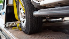 A flatbed tow truck carrying a secured car