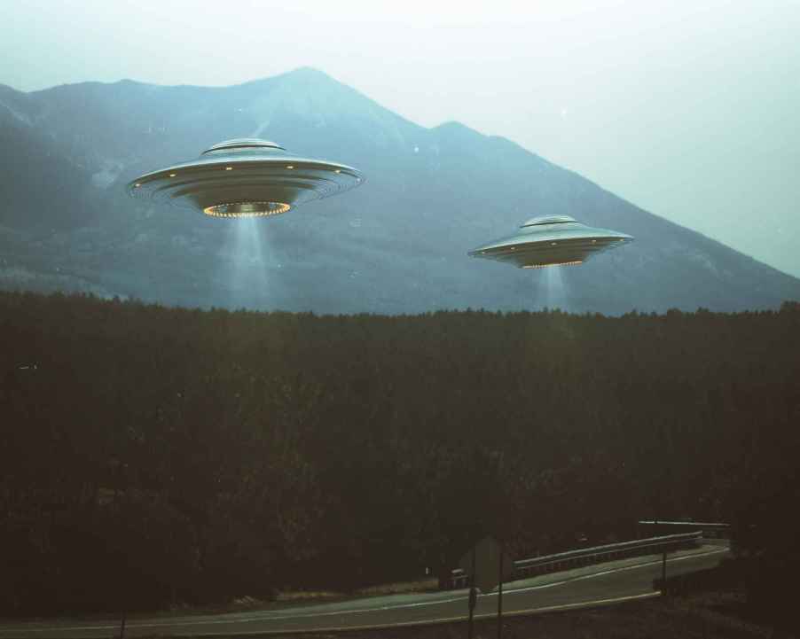 A retro rendering of two UFOs hovering above a road near evergreen woods