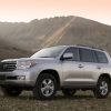 A light metallic 2008 Toyota Land Cruiser parked in front of a green mountain in left front angle view